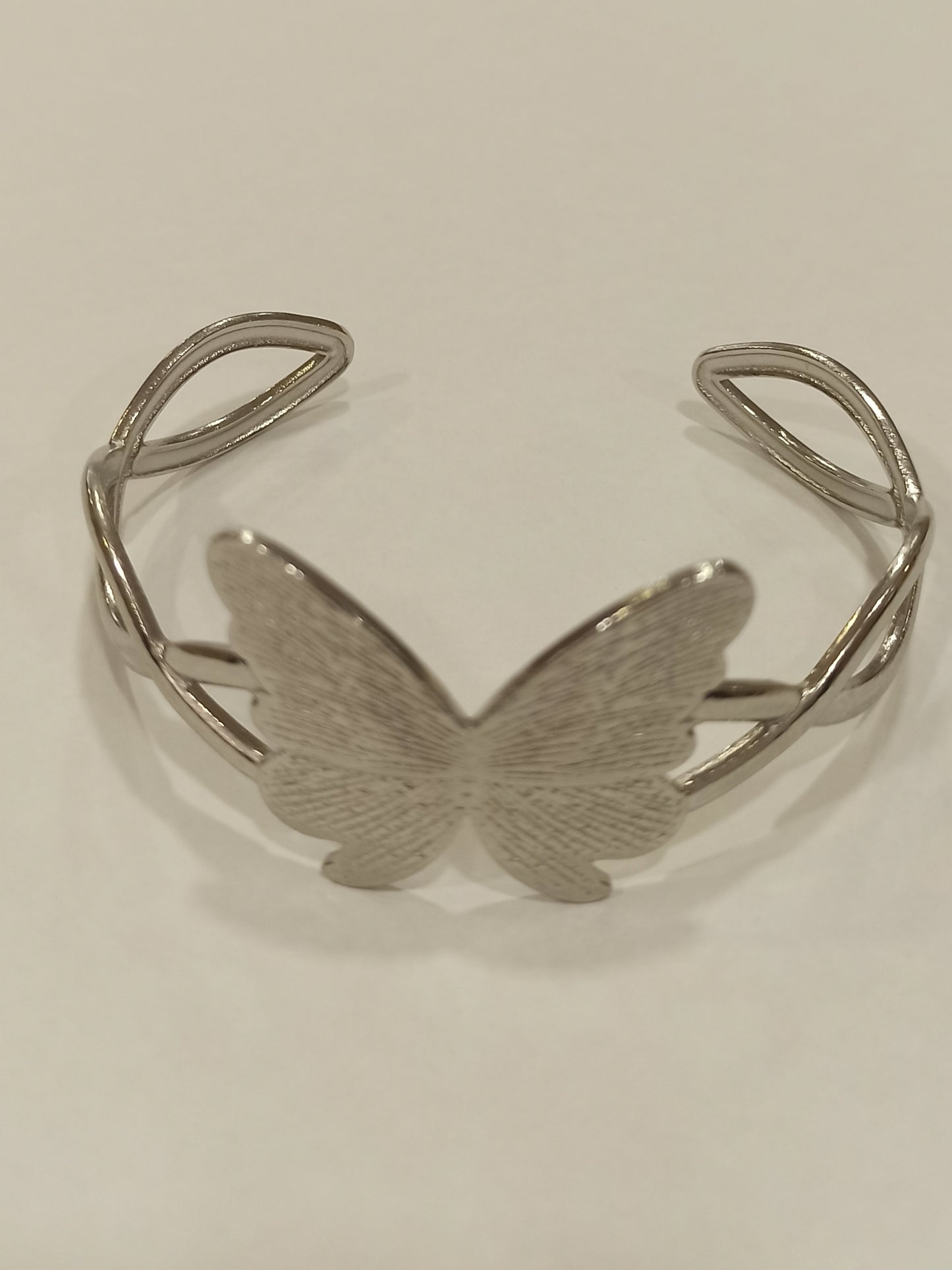 Pulsera rígida plateada con mariposa central 3x3cm