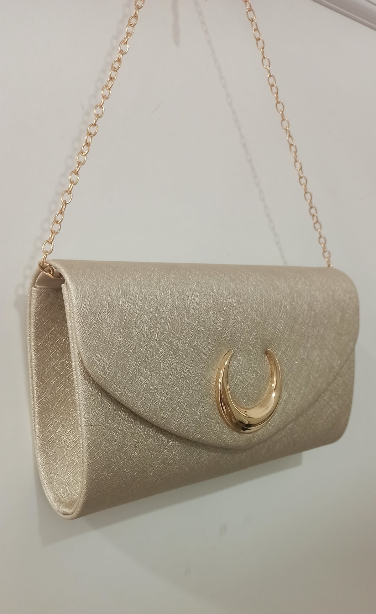 Bolso de fiesta dorado con cadena y detalle de herradura