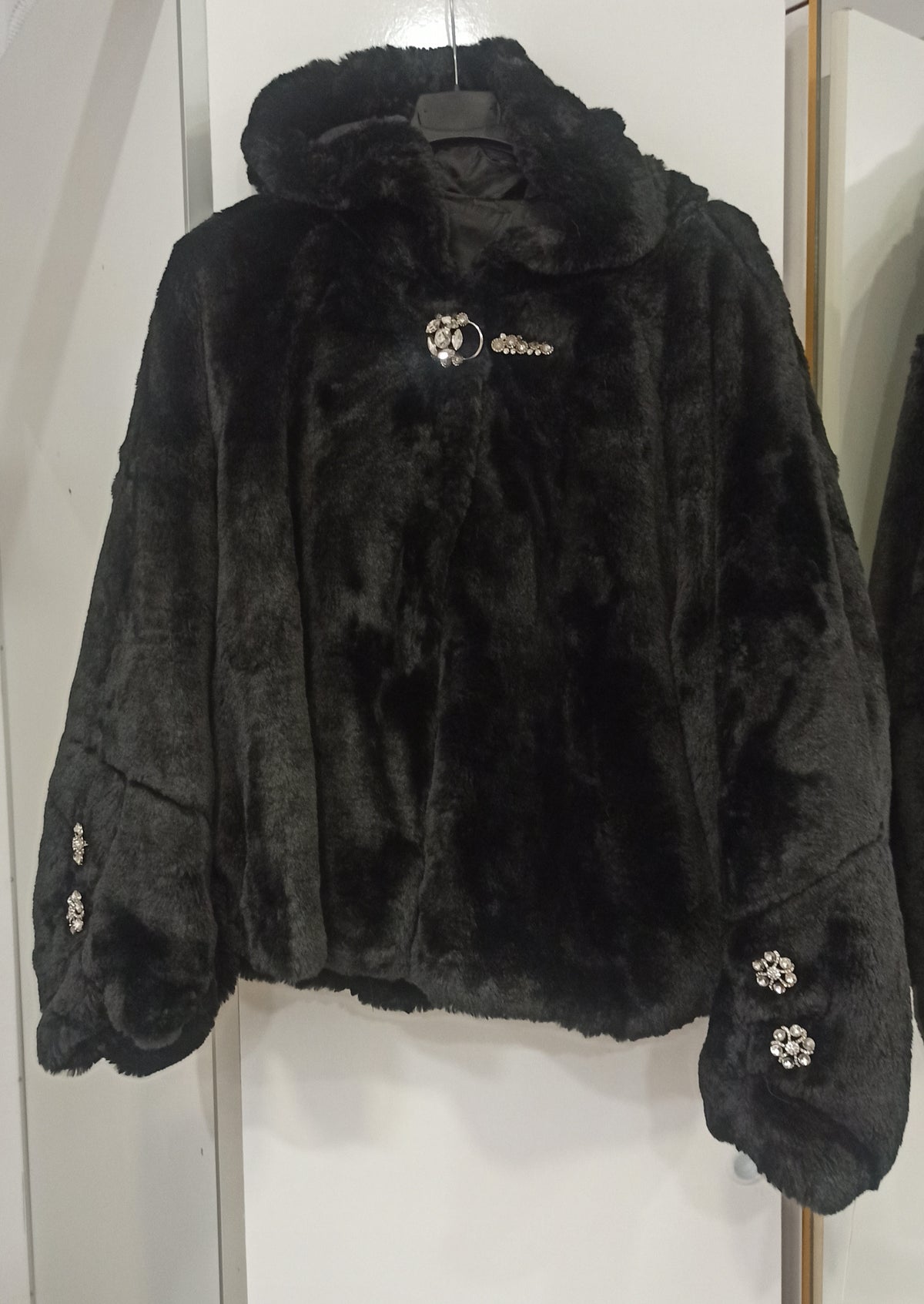 Chaqueta de pelo negra con capucha y broche joya