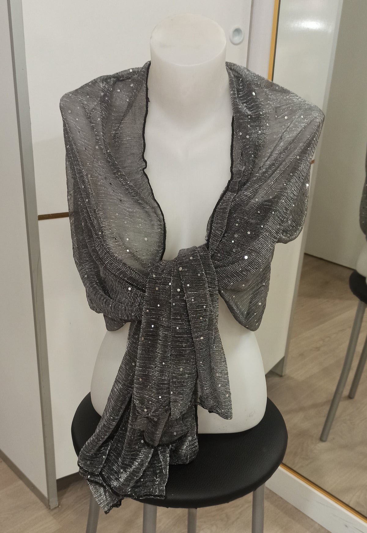 Detalle de tejido gris antracita con brillo y aplicaciones circulares