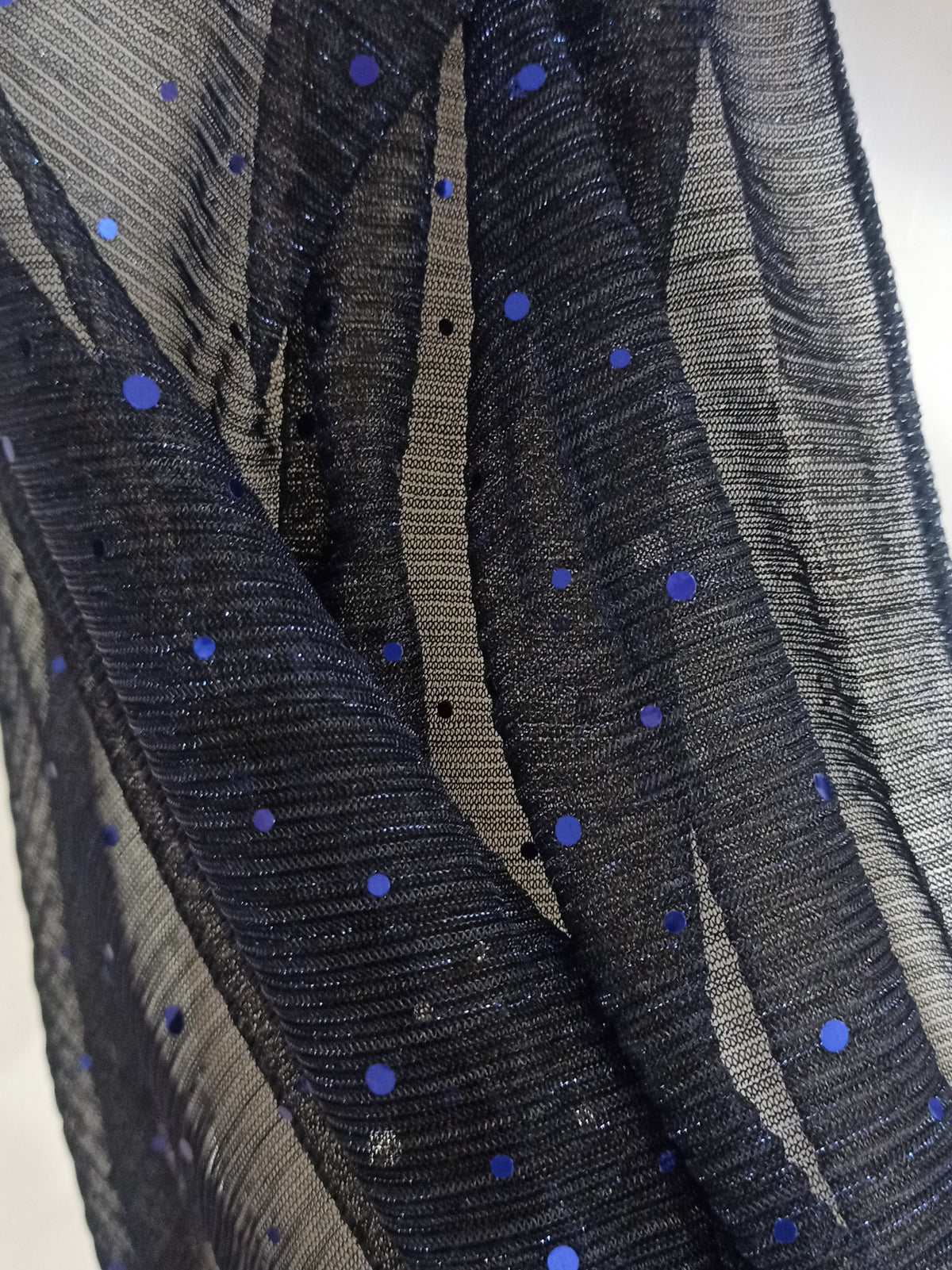 Detalle del tejido azul marino translúcido y puntos brillantes