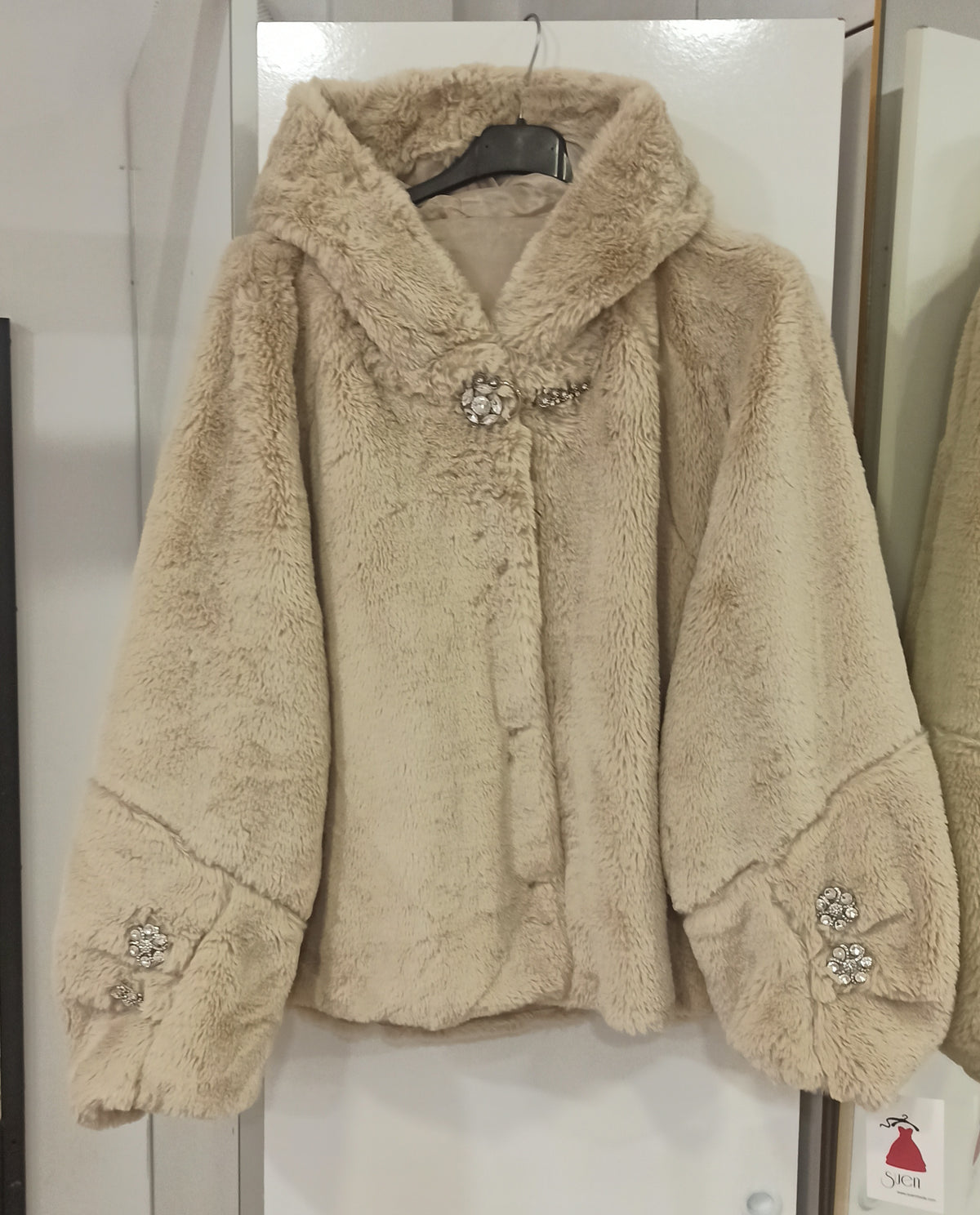 Detalle del broche joya de la chaqueta beige