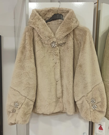 Detalle del broche joya de la chaqueta beige