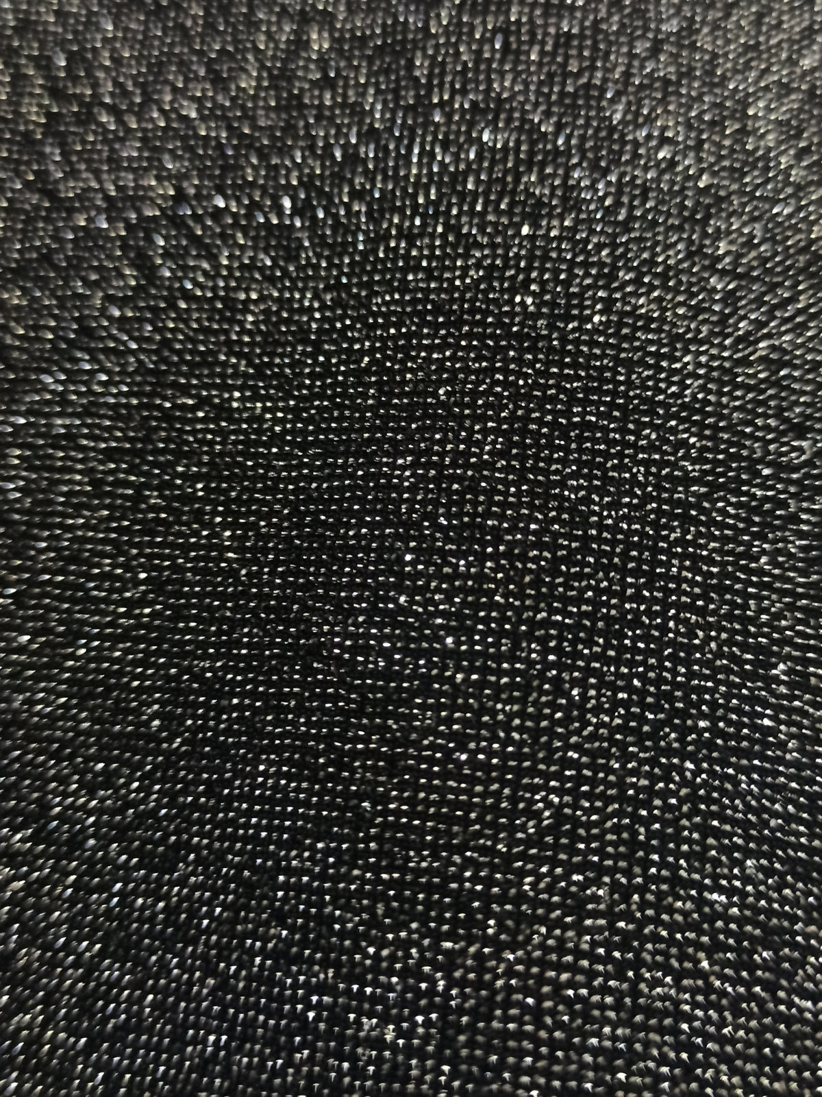 Detalle real del tejido oscuro con hilo plateado