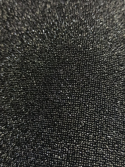 Detalle real del tejido oscuro con hilo plateado