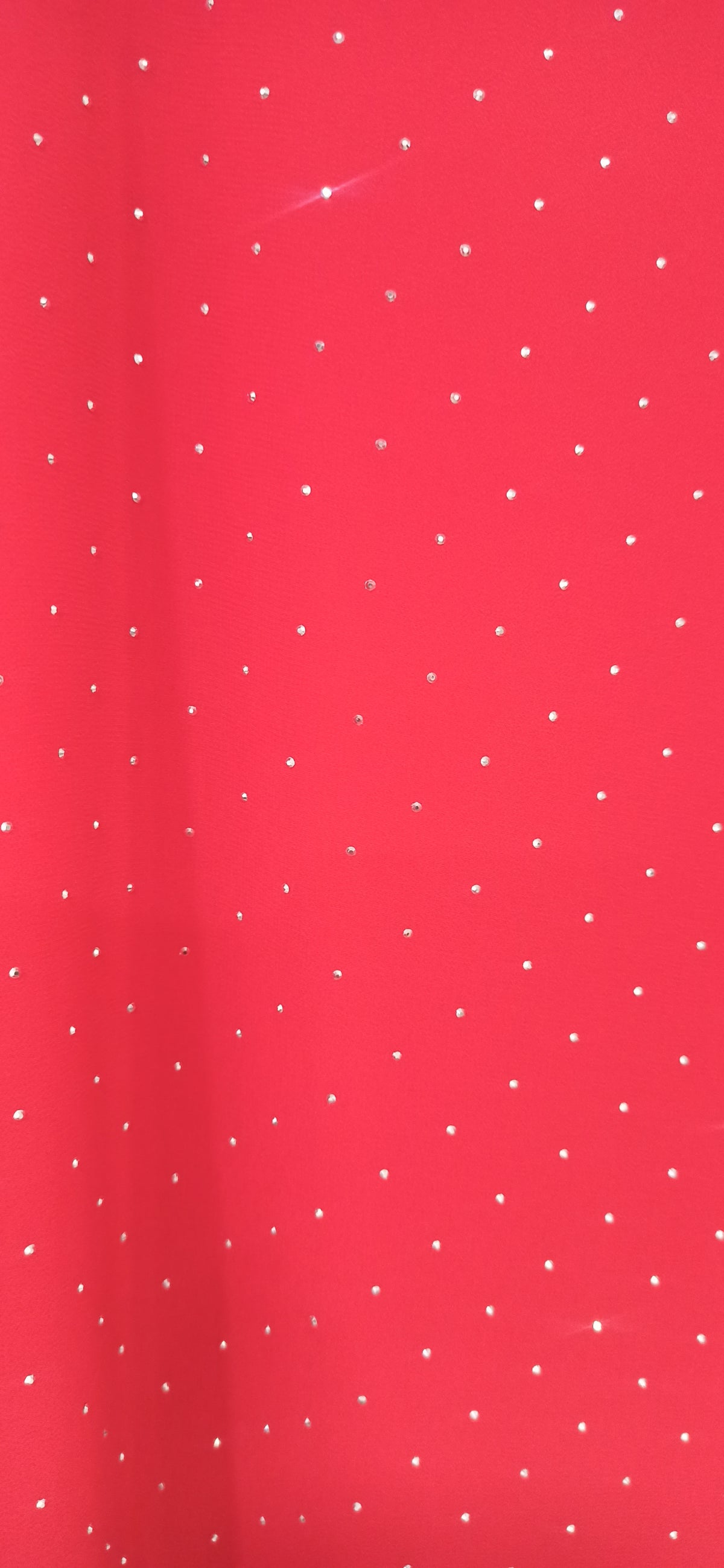 Detalle del tejido rojo y los pequeños brillos de la blusa