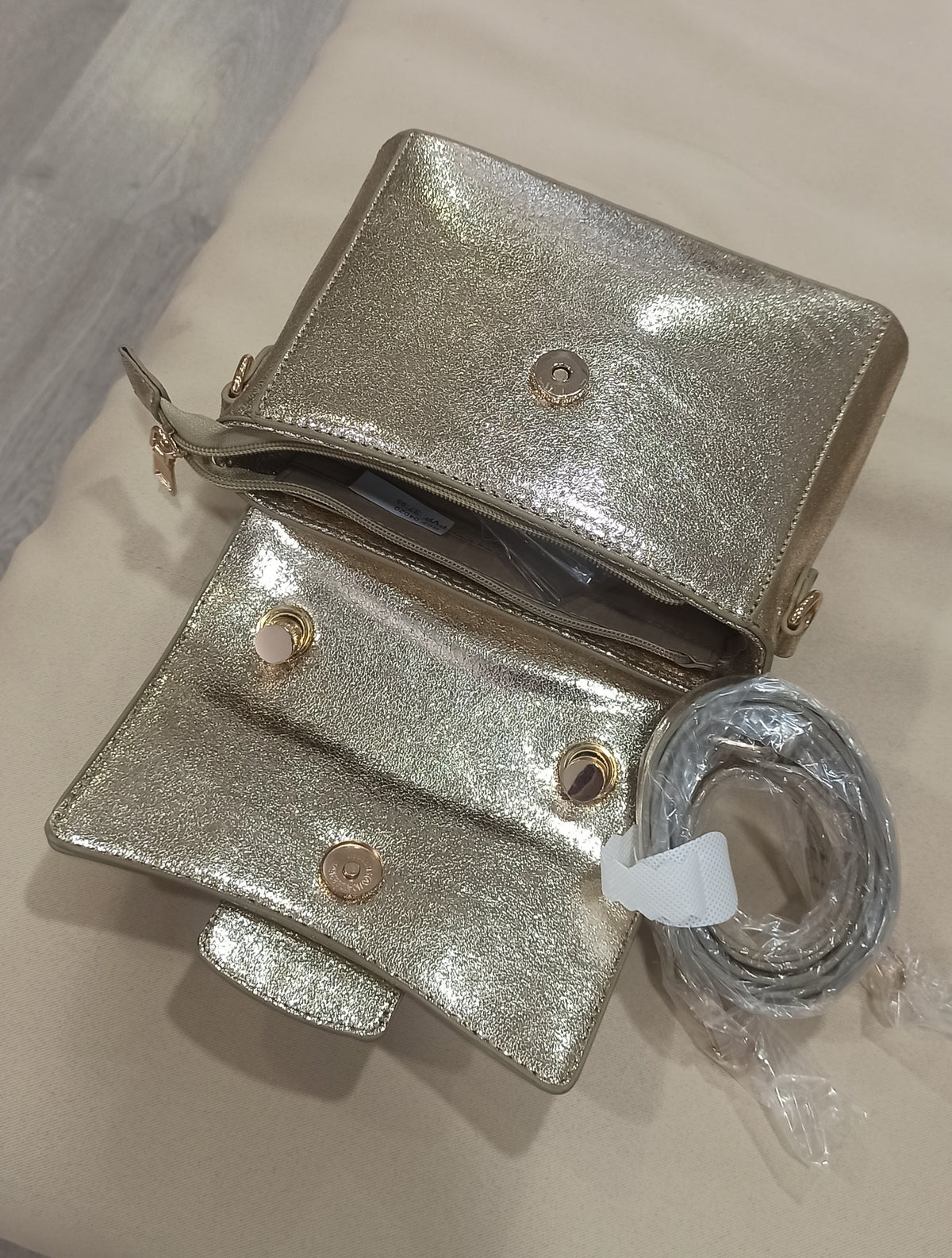 Bolso de fiesta dorado con asa de nudos y cierre decorativo