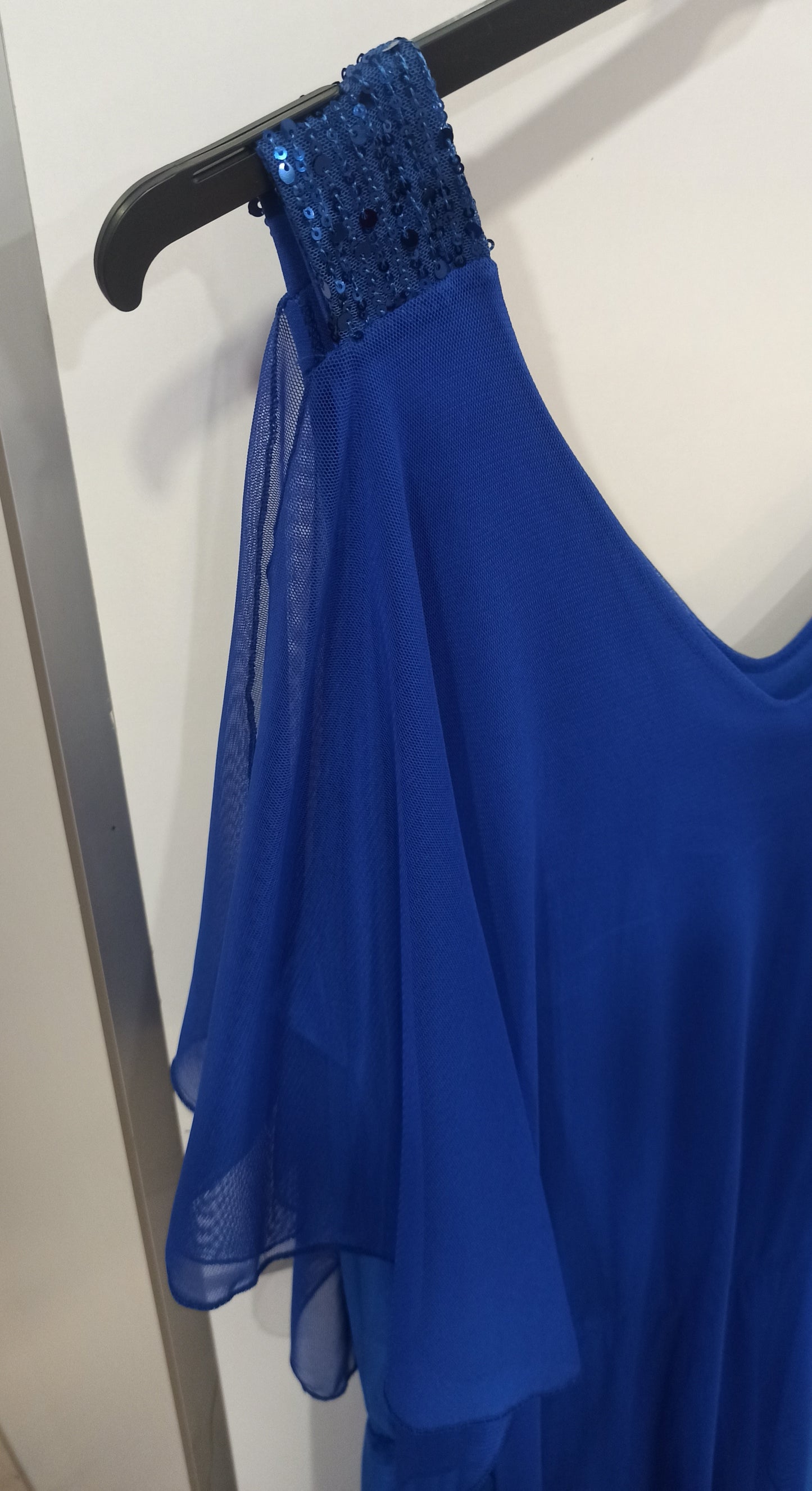 detalle mono elegante con capa de tul y tirantes de lentejuelas azul