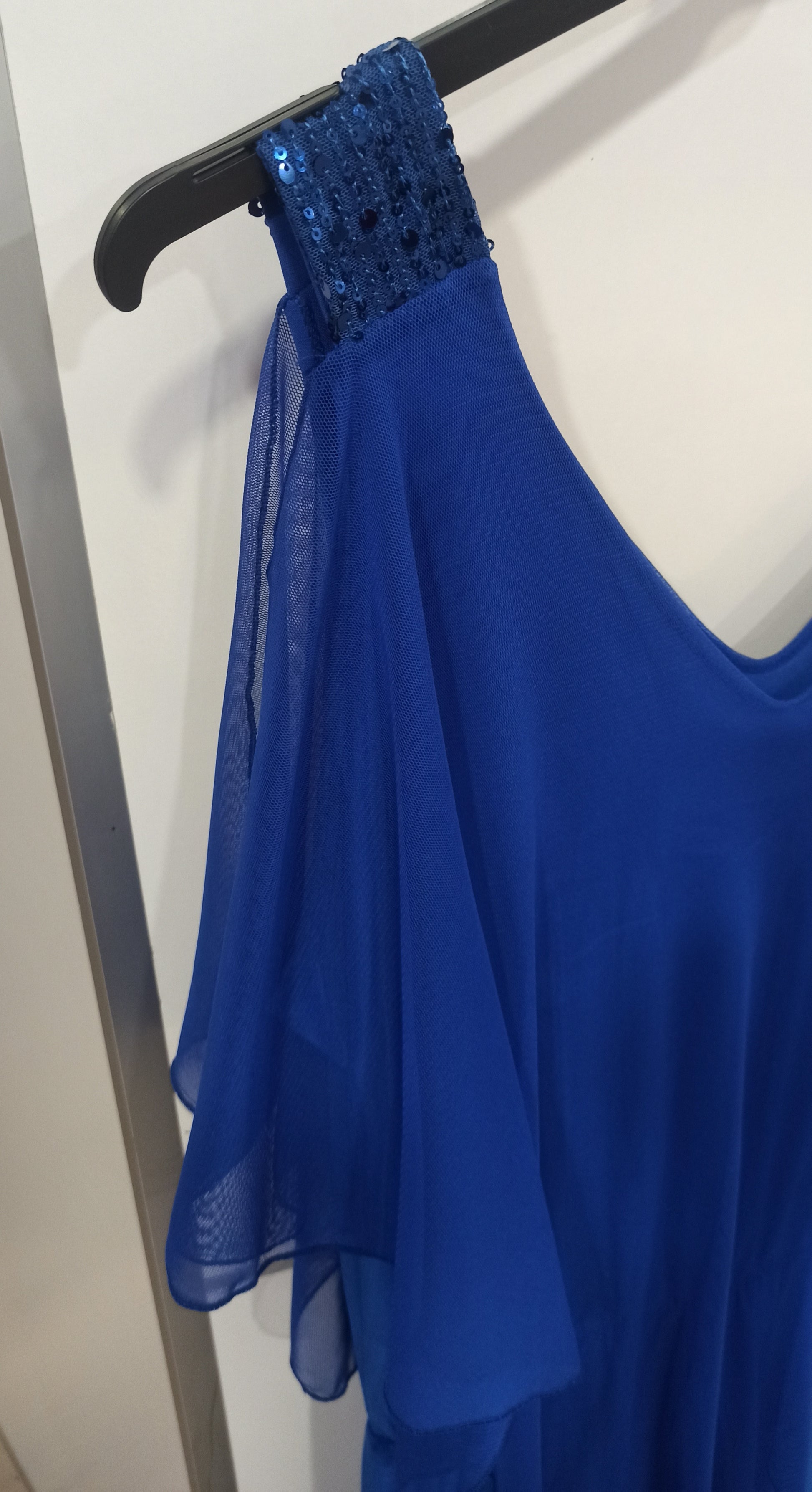 detalle mono elegante con capa de tul y tirantes de lentejuelas azul