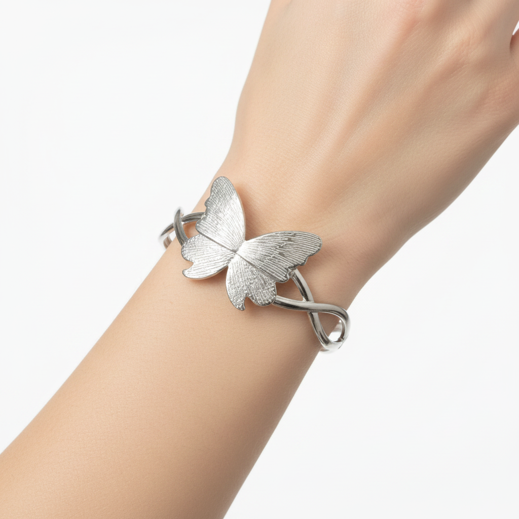 Mano de modelo con pulsera rígida plateada mariposa