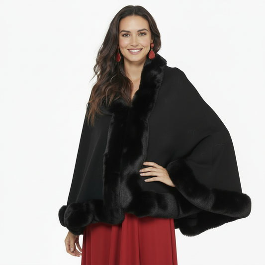 Modelo con capa pashmina negra con pelo y un brazo apoyado en la cintura sobre fondo blanco