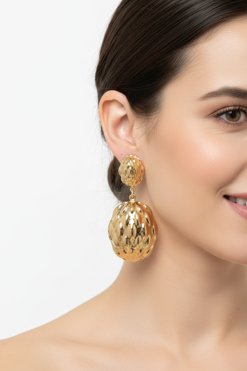 Modelo sonriente con pendientes dorados texturizados fondo blanco