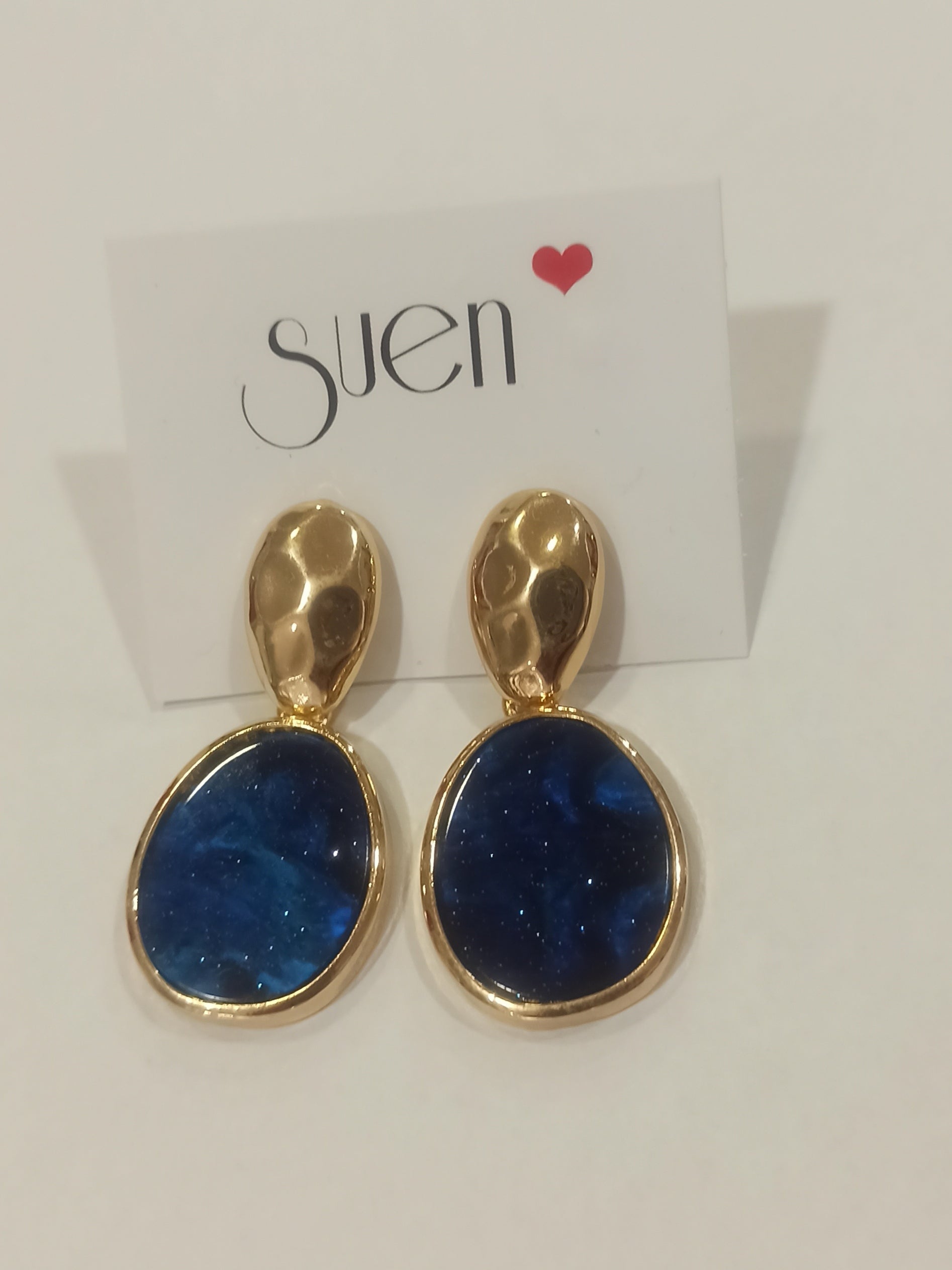 Pendientes largos dorados con piedra azul marino en maniquí