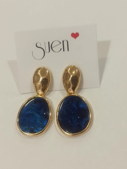 Pendientes largos dorados con piedra azul marino en maniquí